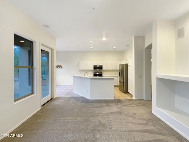 kitchen with white cabinetry, an island with sink, decorative light fixtures, light carpet, and appliances with stainless steel finishes