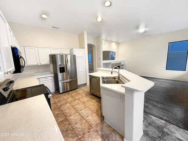 kitchen with a center island with sink, white cabinets, sink, tile patterned flooring, and stainless steel appliances