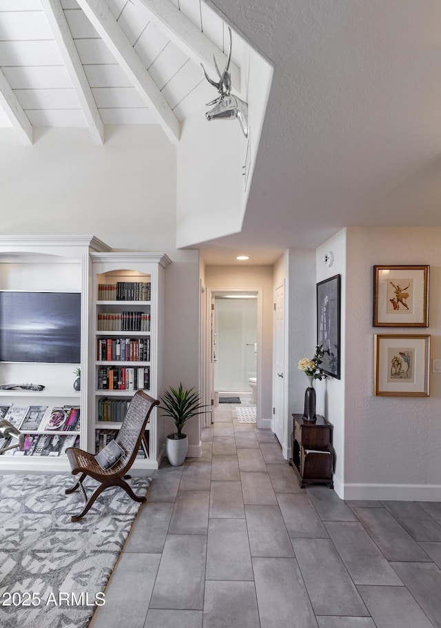 hall featuring tile patterned flooring, a textured ceiling, baseboards, and beamed ceiling