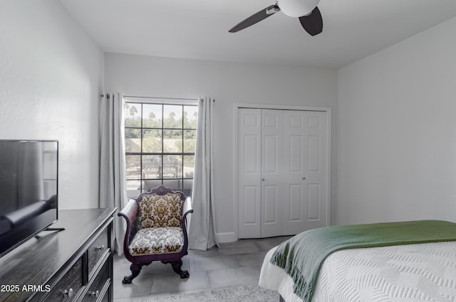 tiled bedroom with ceiling fan and a closet