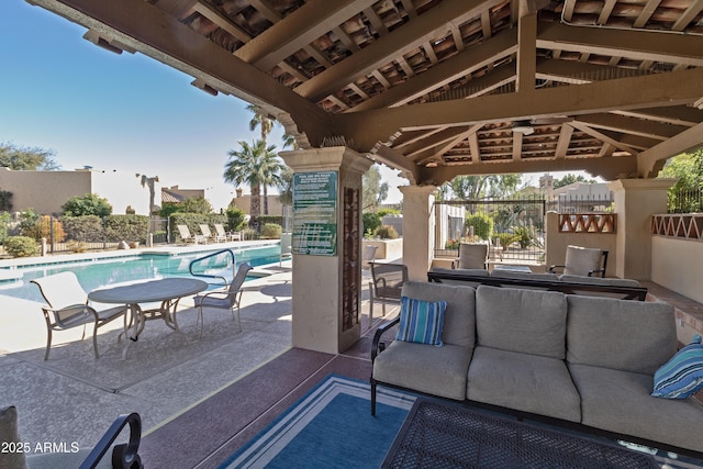 view of patio / terrace with a community pool, fence, an outdoor living space, and a gazebo