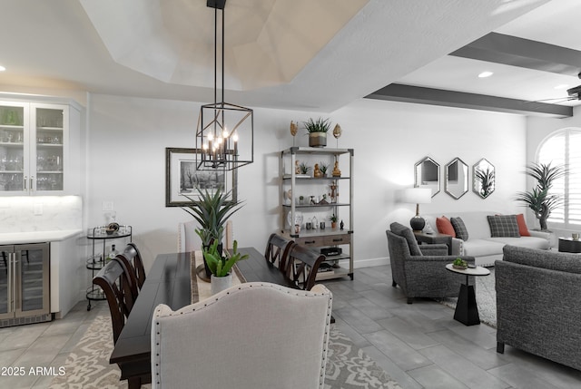 dining space featuring a tray ceiling, beverage cooler, a bar, and recessed lighting