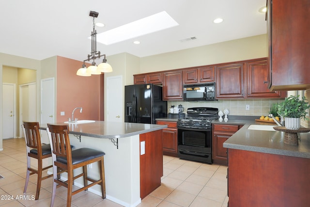 kitchen featuring black appliances, decorative backsplash, a center island, and sink