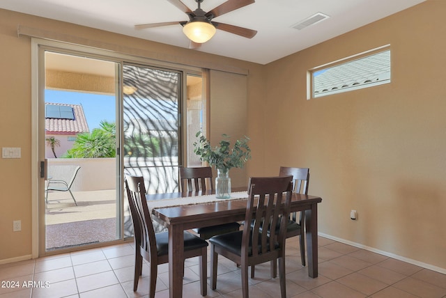 tiled dining space with ceiling fan and plenty of natural light