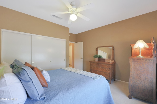 carpeted bedroom with ceiling fan and a closet