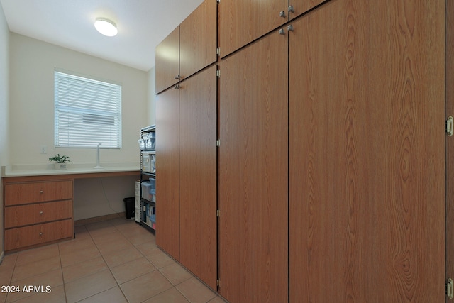 interior space with built in desk and tile patterned floors