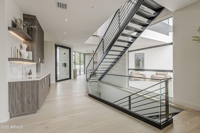 4414 N 29th St, Phoenix, AZ 85016 - hallway featuring light wood-type flooring, stairs, expansive windows, a sink, and recessed lighting