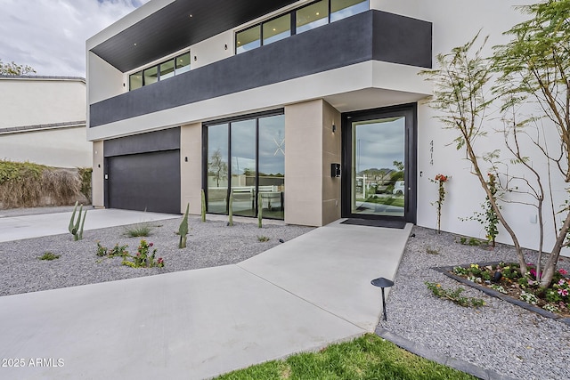 4414 N 29th St, Phoenix, AZ 85016 - doorway to property featuring a garage, stucco siding, driveway, and a balcony