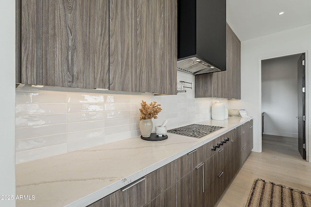 4414 N 29th St, Phoenix, AZ 85016 - kitchen featuring modern cabinets, backsplash, wall chimney range hood, light stone counters, and light wood-type flooring