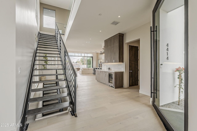 4414 N 29th St, Phoenix, AZ 85016 - stairs featuring wood finished floors, wine cooler, baseboards, and recessed lighting