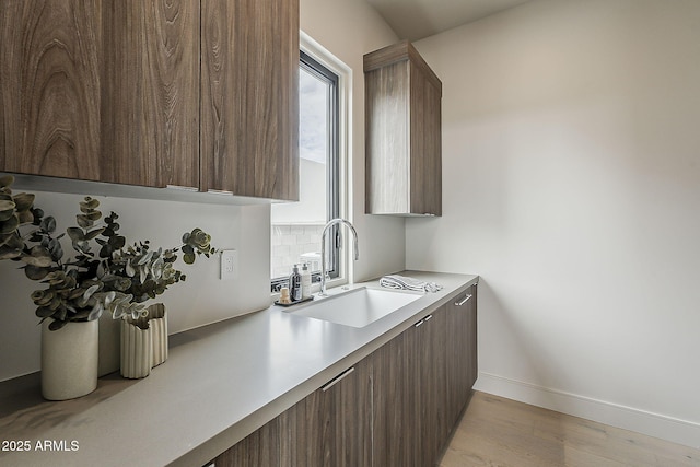 4414 N 29th St, Phoenix, AZ 85016 - kitchen featuring a sink, light wood finished floors, light countertops, baseboards, and tasteful backsplash
