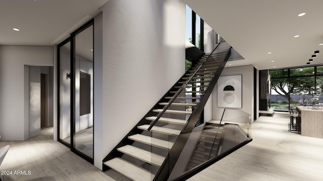 stairway featuring wood-type flooring and floor to ceiling windows