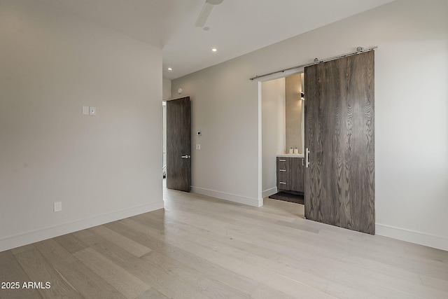 4414 N 29th St, Phoenix, AZ 85016 - unfurnished room with light wood-style flooring, a barn door, baseboards, recessed lighting, and a ceiling fan