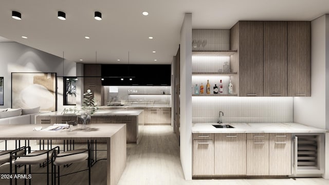 kitchen with light stone countertops, sink, wine cooler, light hardwood / wood-style flooring, and kitchen peninsula