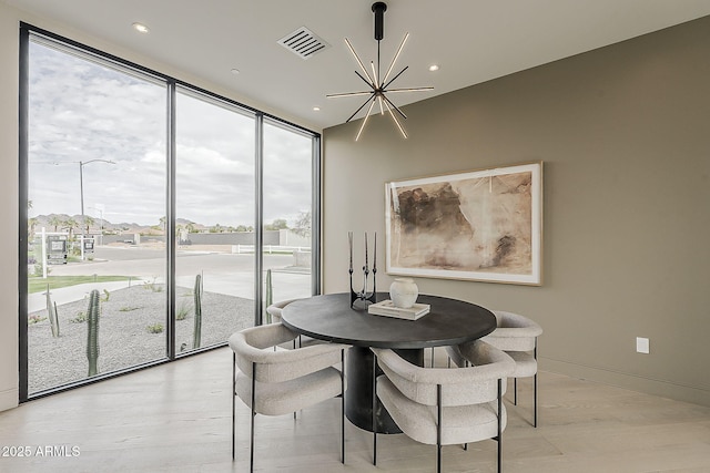 4414 N 29th St, Phoenix, AZ 85016 - dining room with a chandelier, floor to ceiling windows, recessed lighting, light wood-type flooring, and baseboards