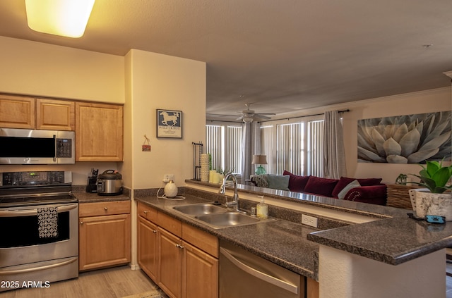 19777 N 76th St Unit 2142, Scottsdale, AZ 85255 - kitchen with stainless steel appliances, open floor plan, light wood finished floors, ceiling fan, and a peninsula