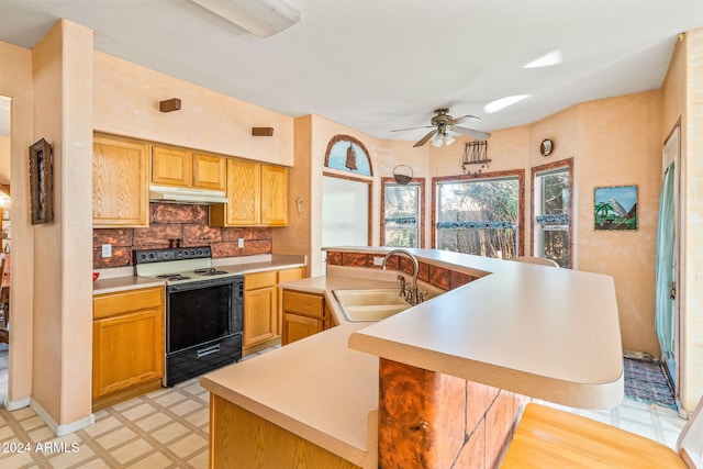 kitchen with backsplash, a kitchen island with sink, white range with electric cooktop, sink, and ceiling fan