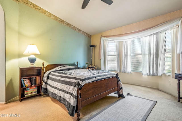 bedroom featuring light carpet, multiple windows, vaulted ceiling, and ceiling fan