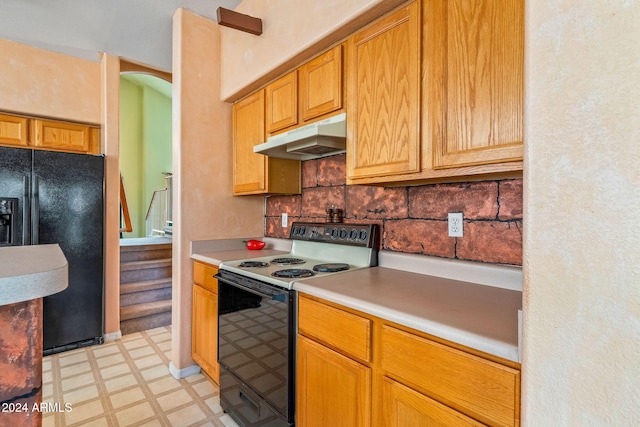 kitchen featuring electric range, tasteful backsplash, and black refrigerator with ice dispenser