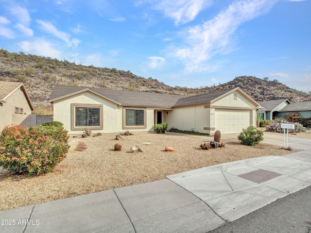 ranch-style home with a garage and a mountain view