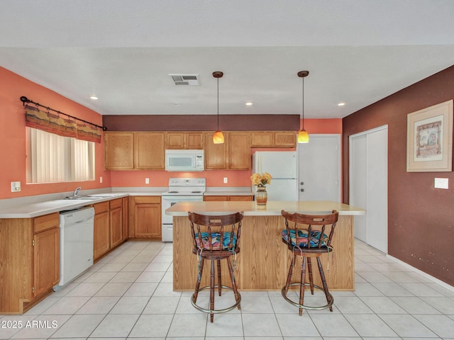 kitchen with a kitchen island, pendant lighting, sink, a breakfast bar area, and white appliances