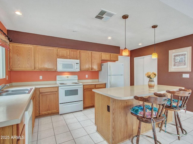 kitchen with sink, a center island, hanging light fixtures, light tile patterned floors, and white appliances