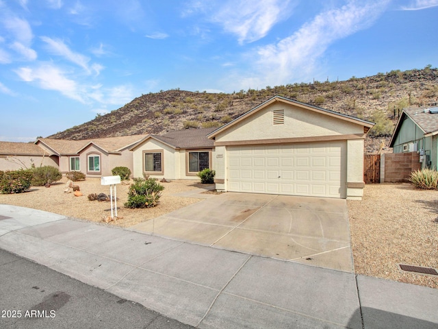 ranch-style home featuring a garage and a mountain view