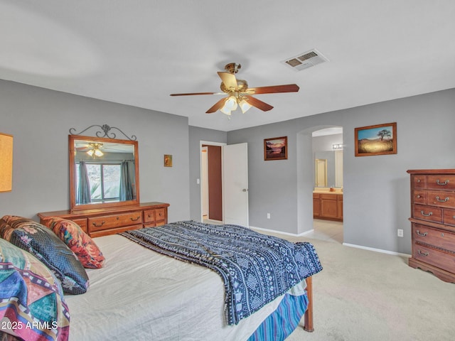 bedroom featuring connected bathroom, light colored carpet, and ceiling fan