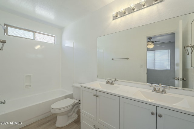 full bathroom with hardwood / wood-style floors, vanity, shower / washtub combination, ceiling fan, and toilet