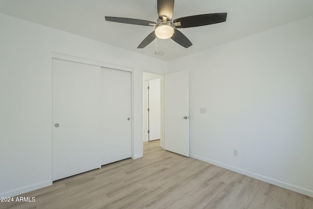 unfurnished bedroom featuring ceiling fan, light wood-type flooring, and a closet