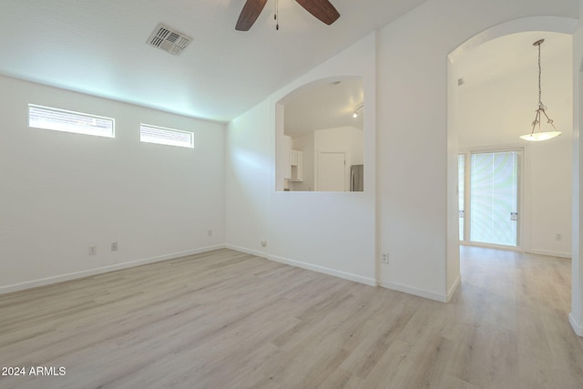 unfurnished room with ceiling fan, a healthy amount of sunlight, light wood-type flooring, and lofted ceiling