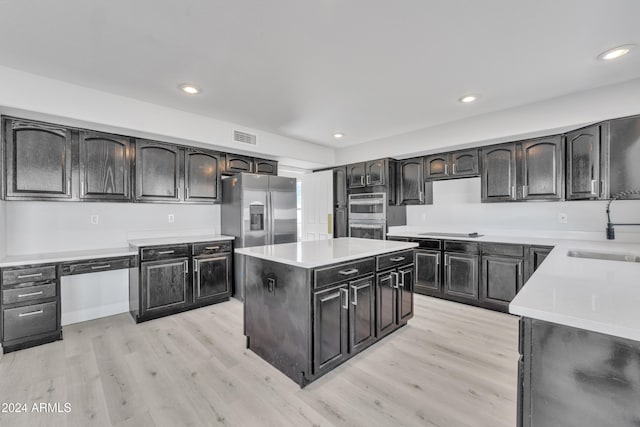 kitchen with sink, a center island, light hardwood / wood-style floors, and appliances with stainless steel finishes