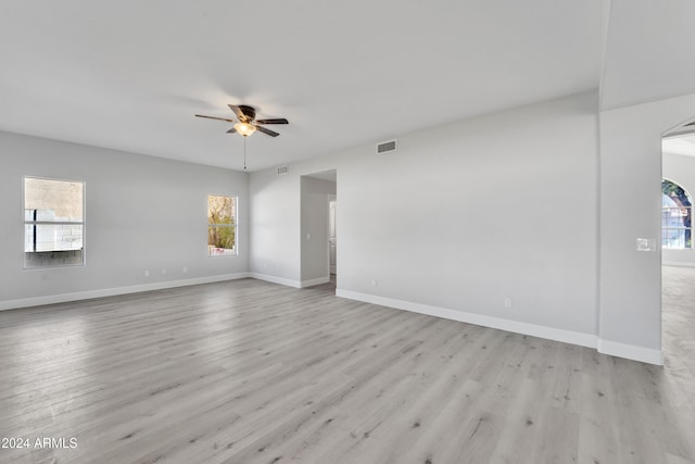 empty room featuring a wealth of natural light, light hardwood / wood-style flooring, and ceiling fan