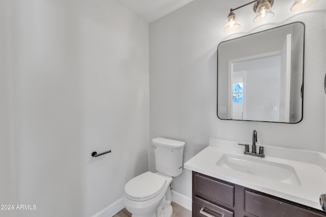 bathroom with wood-type flooring, vanity, and toilet