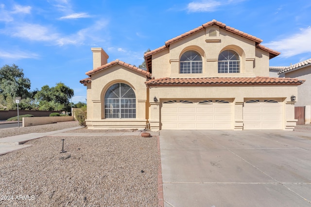 mediterranean / spanish-style house with a garage