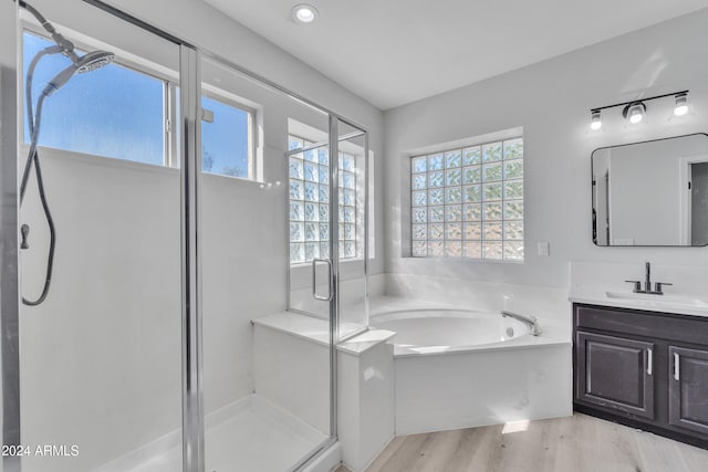 bathroom featuring plenty of natural light, vanity, independent shower and bath, and hardwood / wood-style flooring