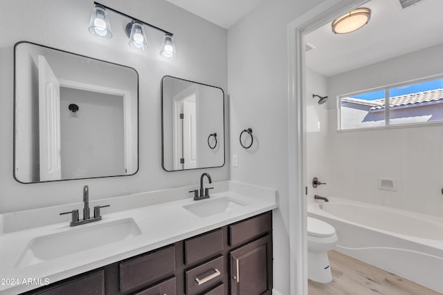 full bathroom featuring hardwood / wood-style floors, vanity, toilet, and tub / shower combination