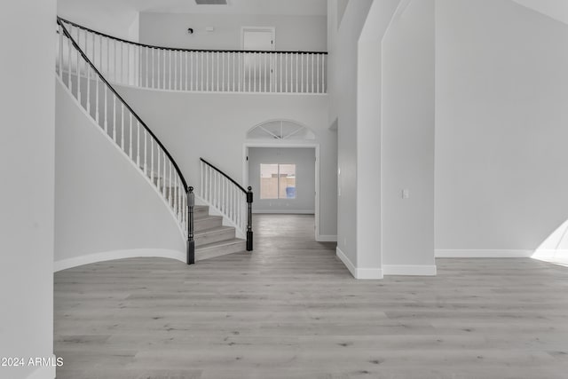 entryway with a high ceiling and light hardwood / wood-style flooring