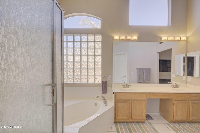 bathroom with tile patterned floors, a bathtub, and vanity