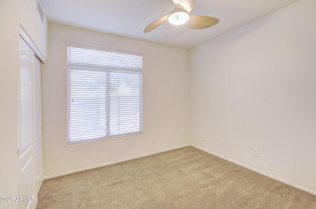 carpeted spare room with ceiling fan