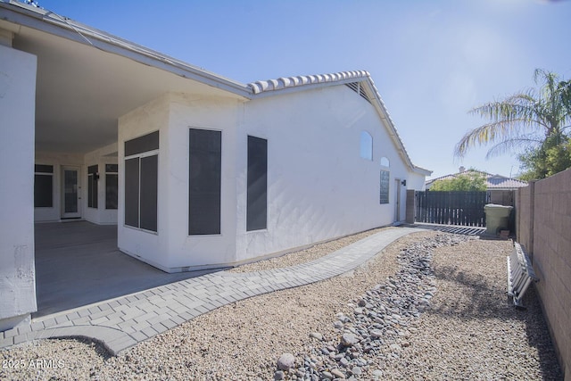 view of property exterior with a patio area