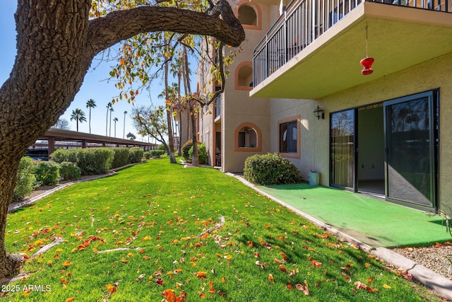 view of yard with a balcony