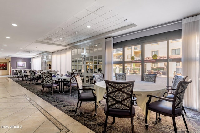 tiled dining space with a tray ceiling