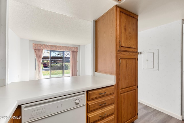 kitchen with light wood-type flooring, a textured ceiling, and white dishwasher