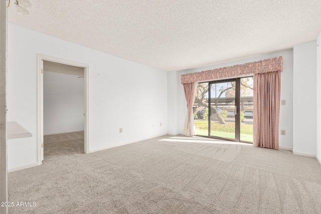 unfurnished room featuring light colored carpet and a textured ceiling