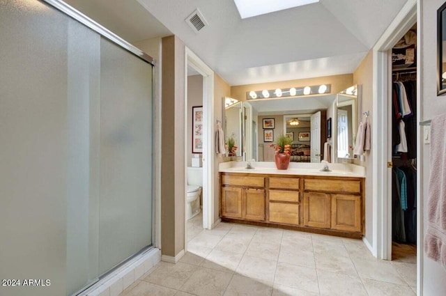 bathroom featuring tile patterned flooring, vanity, toilet, and an enclosed shower