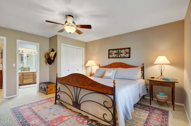 bedroom with connected bathroom, a closet, ceiling fan, and light colored carpet