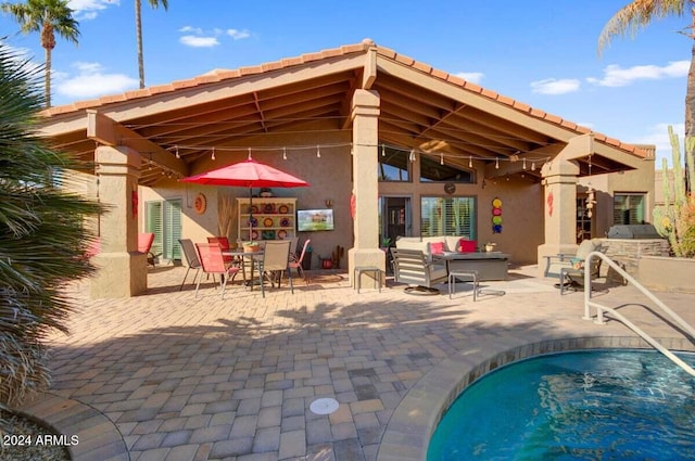 rear view of house with outdoor lounge area and a patio area