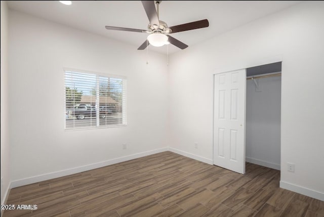unfurnished bedroom with baseboards, a closet, wood finished floors, and ceiling fan