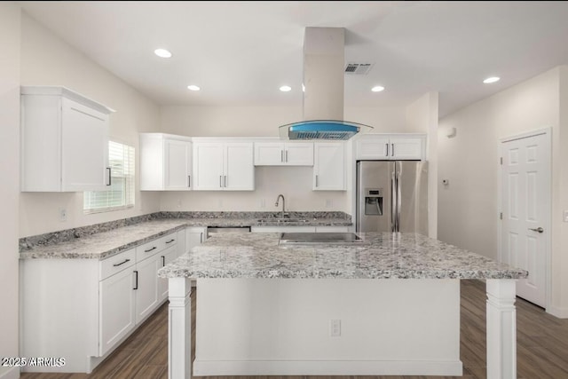 kitchen featuring white cabinets, island exhaust hood, stainless steel appliances, dark wood finished floors, and a sink